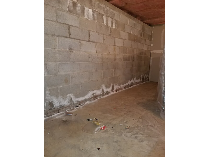 Efflorescence on a block wall (lime salts that come out of the concrete created when water gets stuck in the block) deterioration process | Eco-Dry Waterproofing