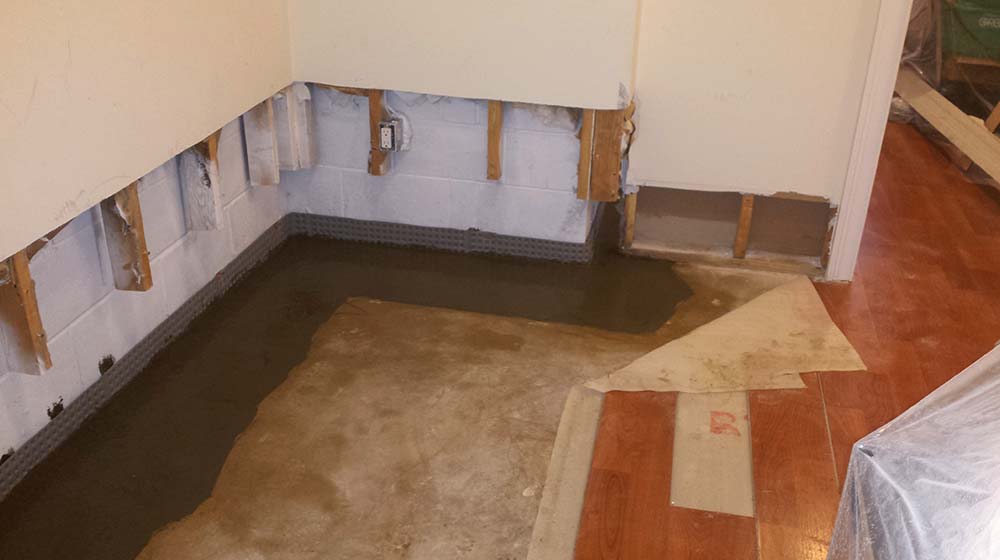 Interior french drain, finished basement (angle 2) | Eco-Dry Waterproofing
